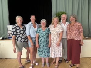 Yvonne Gallimore with colleagues at her retirement party. There are 6 people standing in a group and smiling to camera.